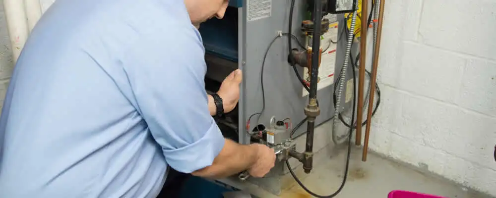 Furnace repair technician inspecting and servicing a home heating system in Oakland, CA