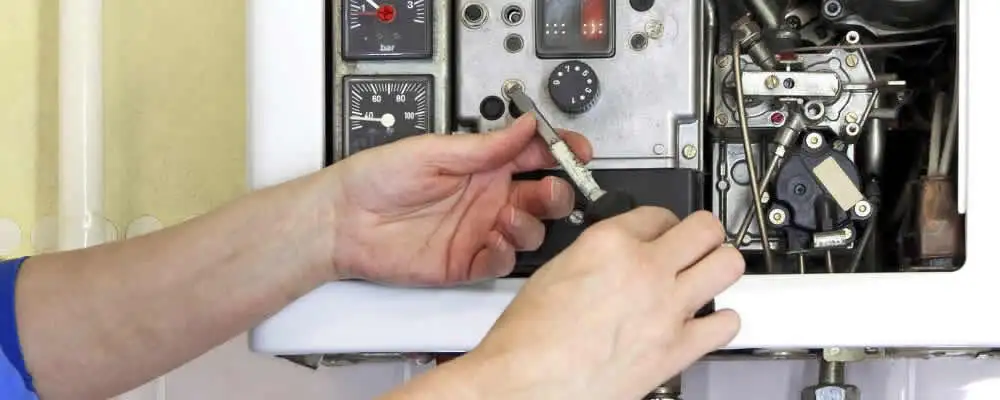 Heating repair technician adjusting boiler controls and components in Oakland, CA
