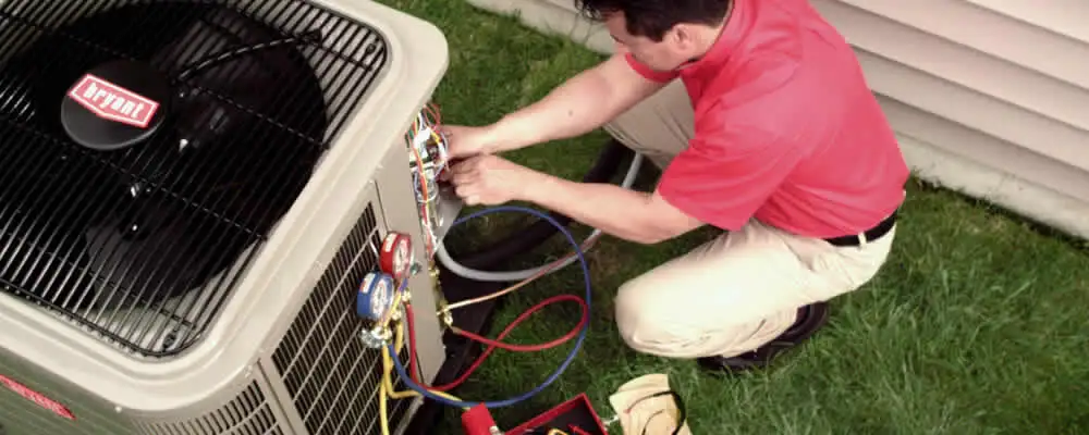 HVAC technician servicing an outdoor air conditioner unit in Oakland, CA