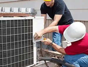 HVAC technicians repairing an outdoor AC unit on a rooftop in Oakland, CA