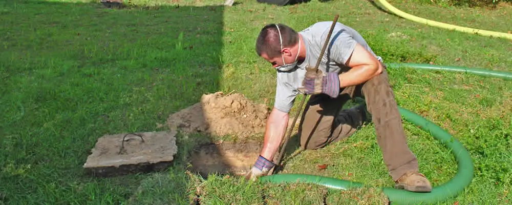 Septic pumping technician servicing a residential septic tank in Oakland, CA