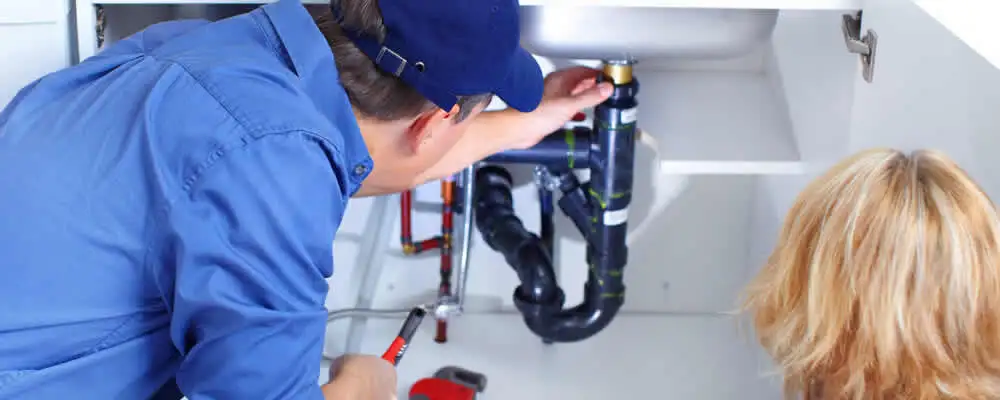 Plumber repairing under-sink drain pipes and fittings in Oakland, CA